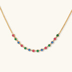 Gold-plated jewelry set with red, green, and blue cubic zirconia stones including necklace, bracelet, and drop earrings.