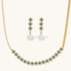 Gold-plated jewelry set with green cubic zirconia floral motifs, featuring matching necklace and pearl drop earrings