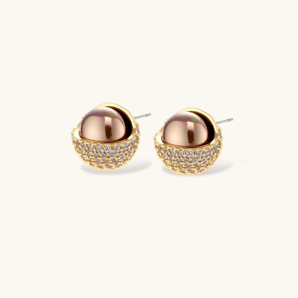 Elegant spherical pendant necklace and earrings set featuring crystal-pavé bottom half in gold or silver finish on white background.