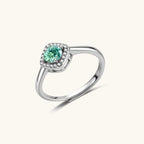 Sterling silver adjustable ring featuring round green moissanite center stone surrounded by clear halo stones